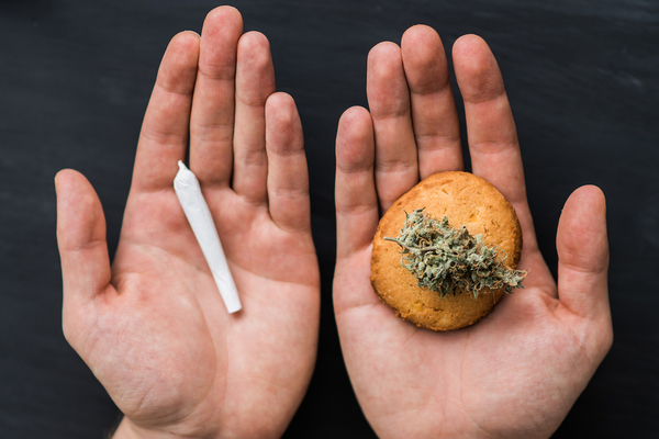 Person holding a cannabis cigarette and cannabis bud.