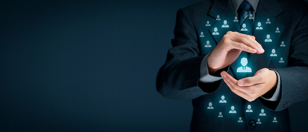 Man in a business suit holding an image of a person in his hands.