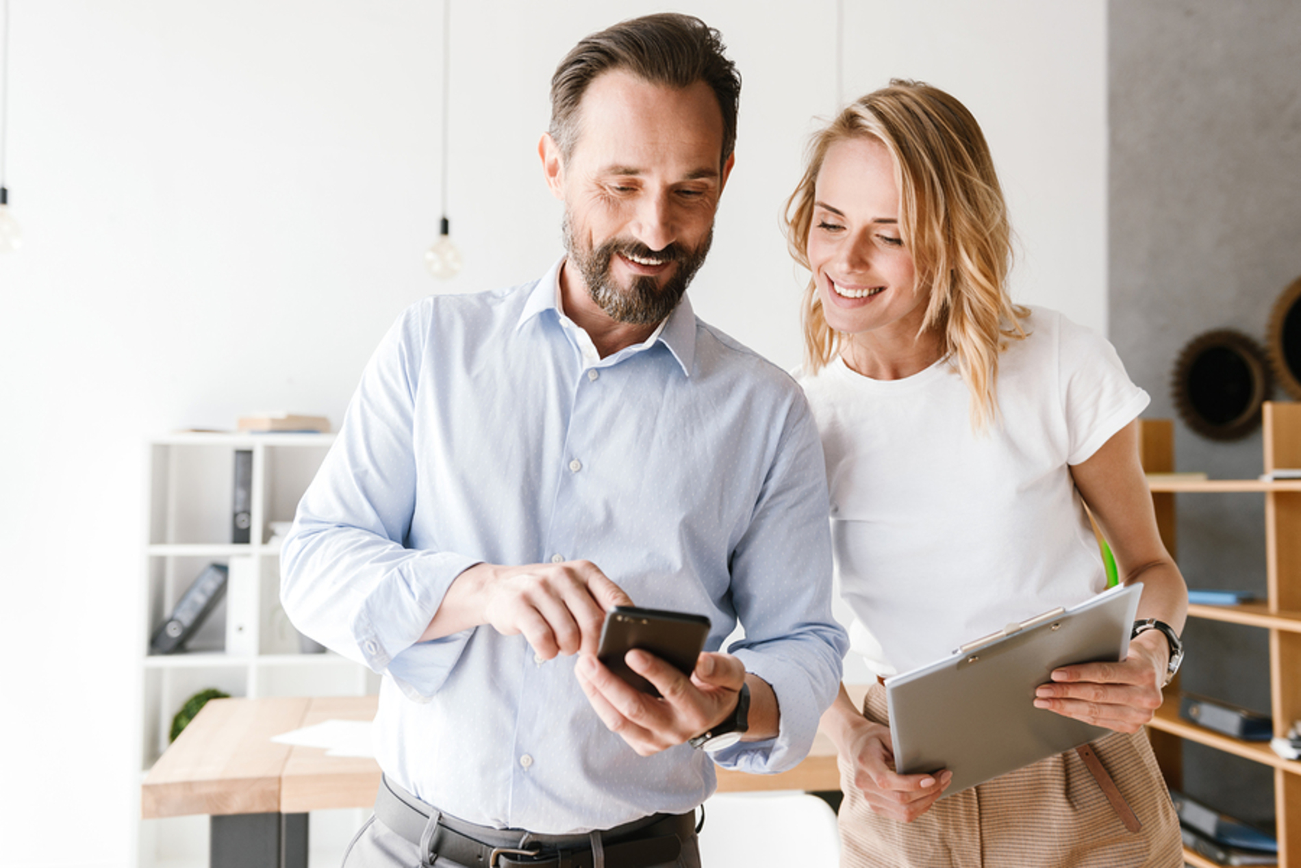 Man and woman looking a phone together.