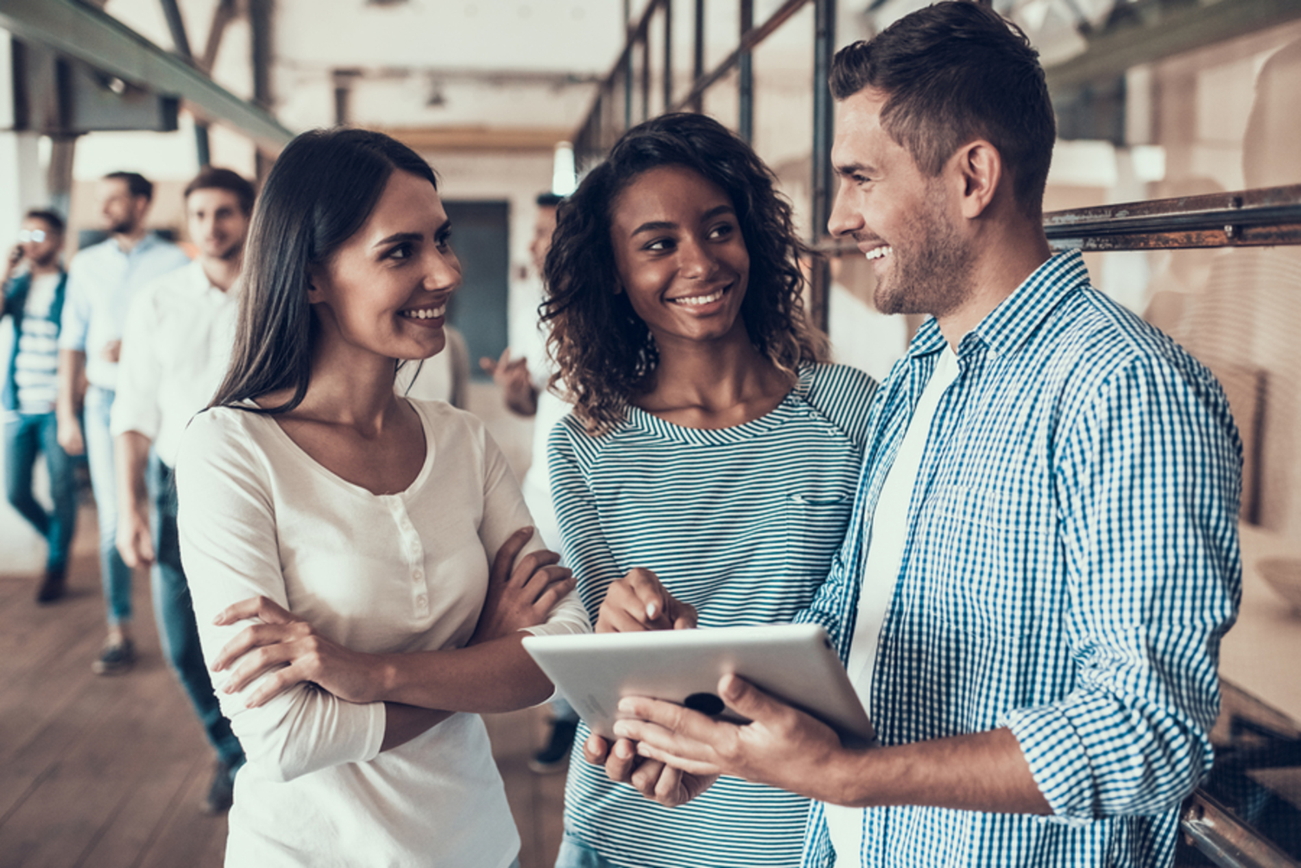 Group of people discussing a project together while looking at a tablet.