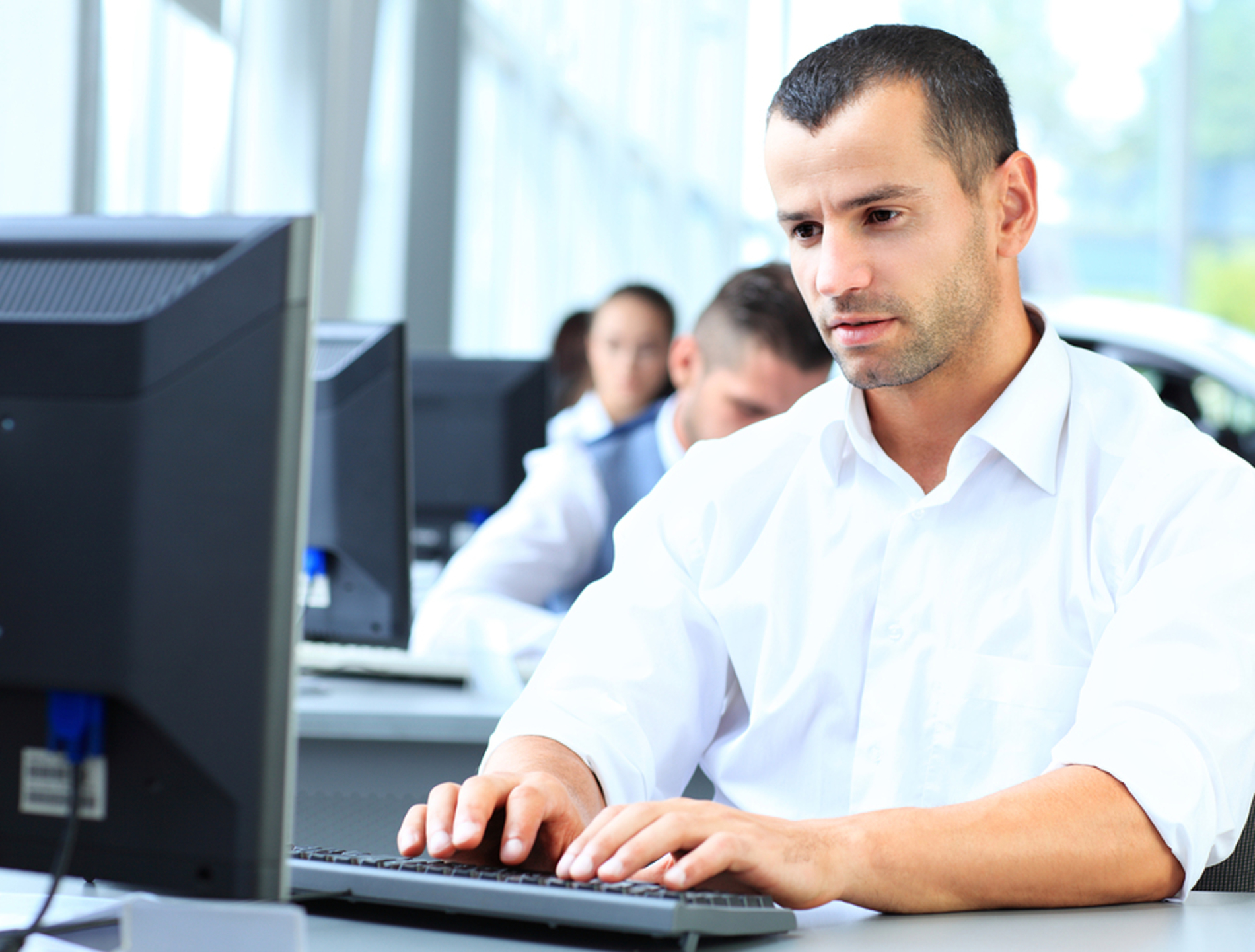 Man typing on a desktop computer.