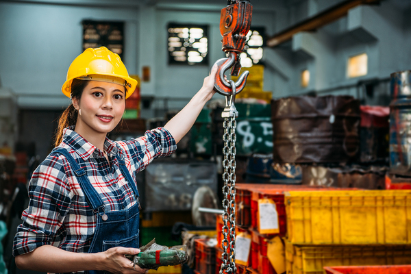 Woman with yellow hardhat working.