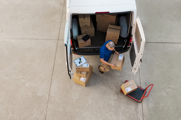 Person unloading boxes from a white van.