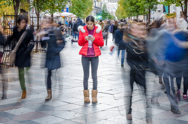 Looking at a phone outside on a walkway.