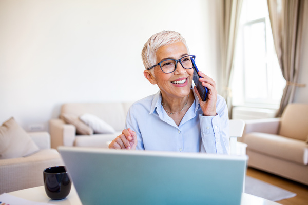 Digital Communications Platform image - Woman talking on the phone in front of her computer.