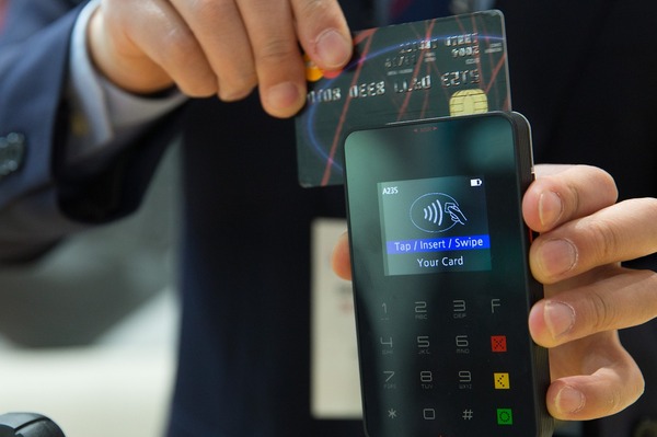 Person making a credit card purchase with a phone.