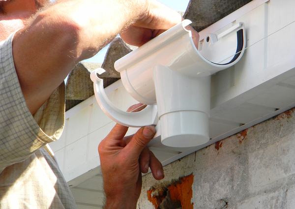 Person installing a downspout.