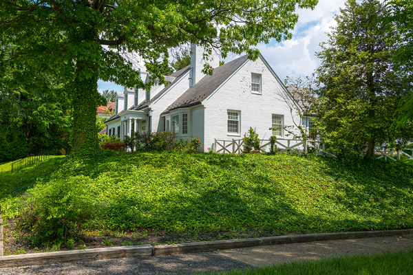 Home with shingled roof and white gutters.