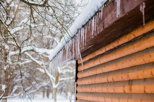 Icicles hanging down the side of a house.