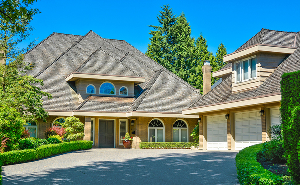 Home with three car garage and shingled roof.