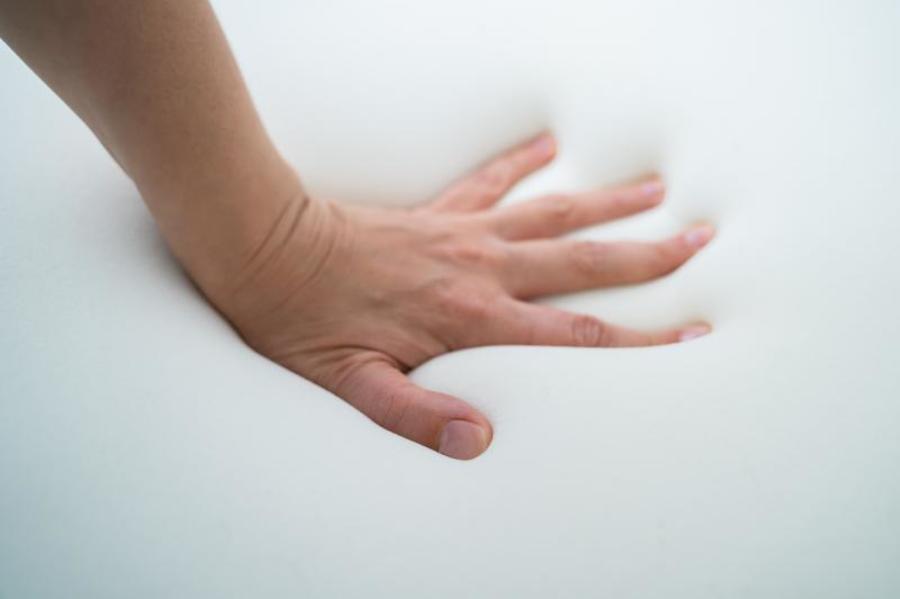 Pushing a hand into a foam cushion.