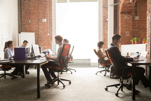 Group of people working together in an open office space.