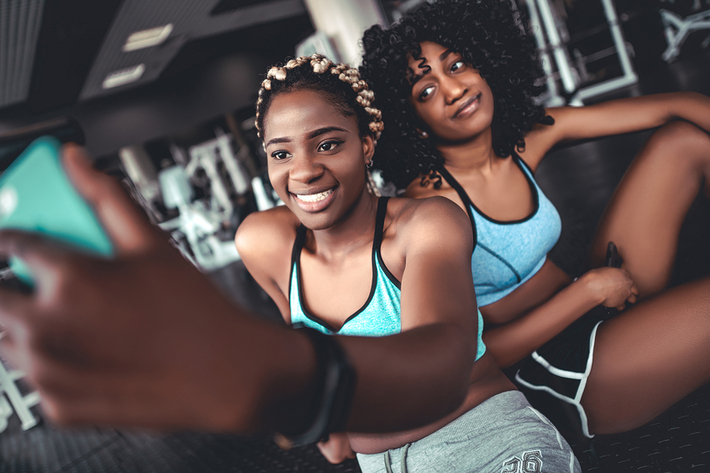 Two women taking a photo together in a gym.