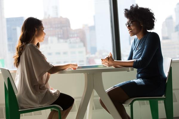 Two people sitting at a table having a discussion.