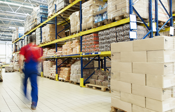 Warehouse with worker walking down hallway.