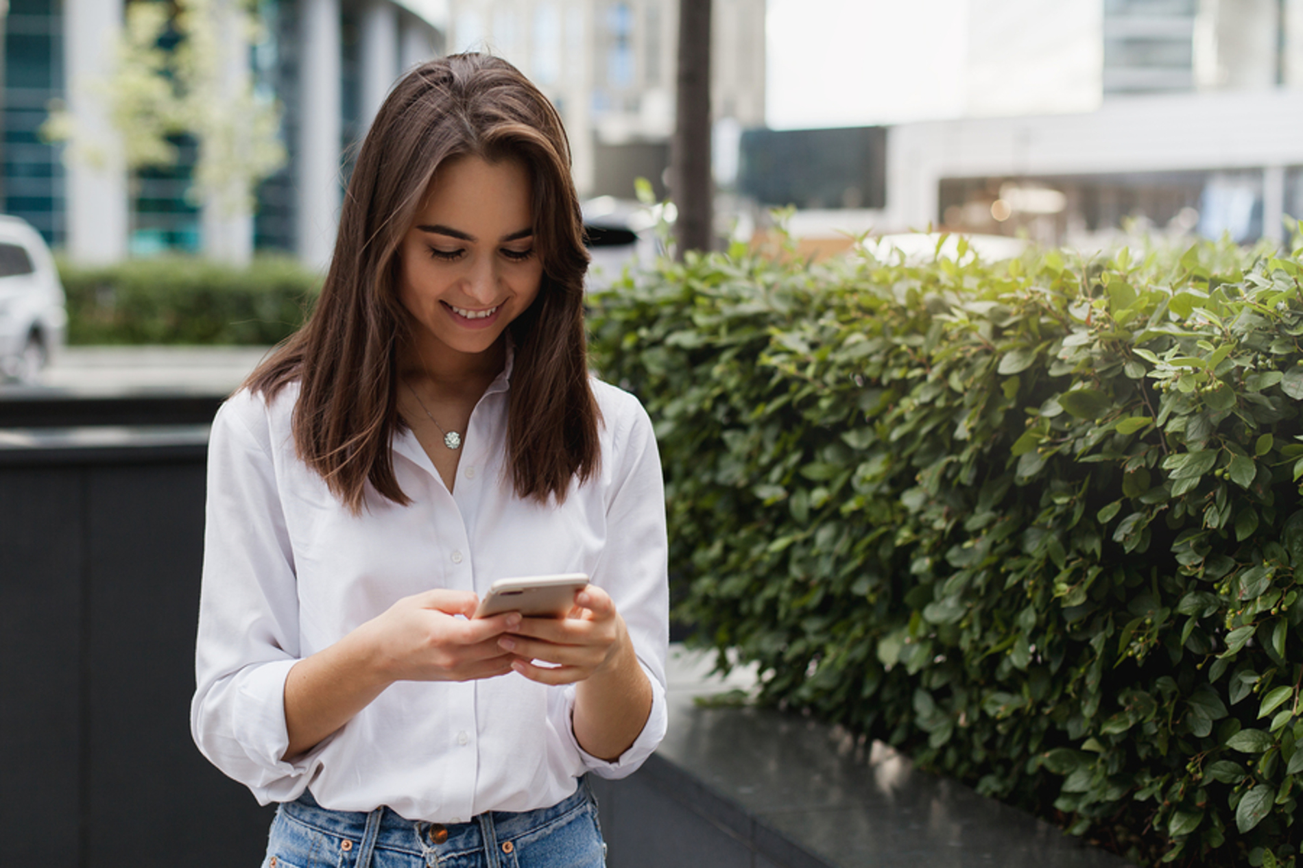 Woman looking at her phone while standing outside. Woman looking at her phone while standing outside.
