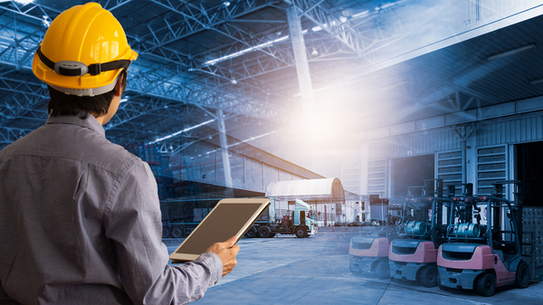 Man with a hardhat holding a tablet.