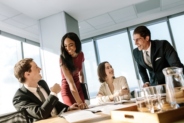 Four people working around a conference table with documents.