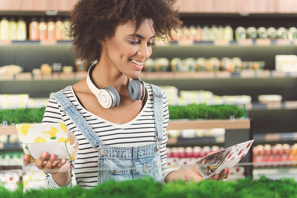 Woman grocery shopping with headphones.