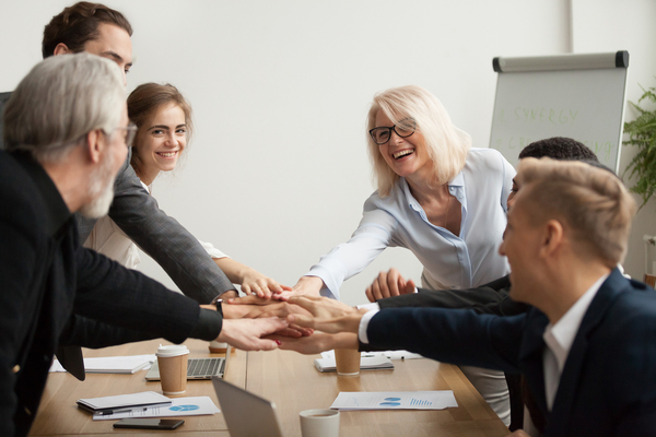 Group of people placing their hands in a circle.