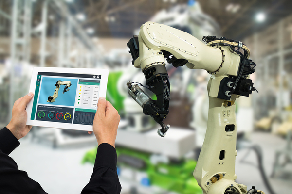 Robotic arm being controlled by a man with a tablet app.
