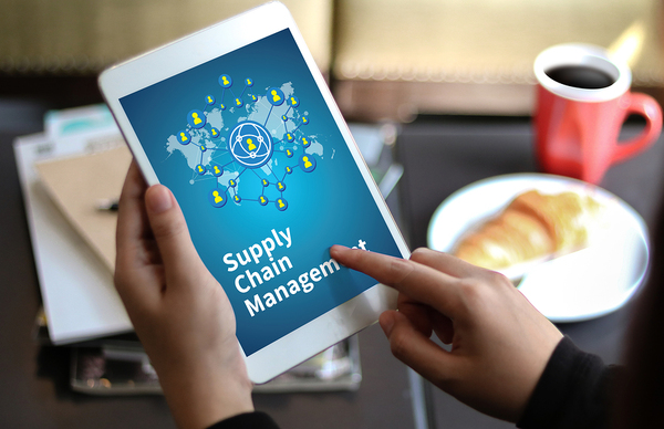 person using a tablet with the words supply chain management displayed.