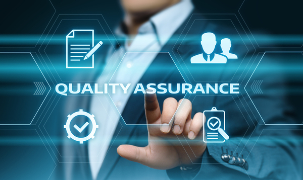 Man in a business suit pointing to the words quality assurance.